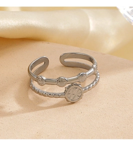 Detail showing a silver double-layered open ring with a circular sunburst relief design
