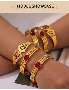 Close-up of vintage gold hollow bangles with colorful gemstones on a female model