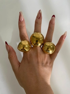 Three different sizes of polished gold dome rings worn on fingers for styling detail