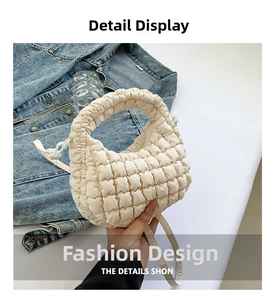 Close-up of quilted ruffles on cream nylon dumpling bag with detailed stitching texture