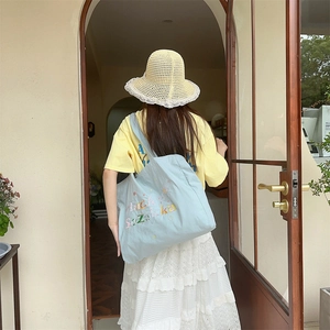 Look d'été avec un grand sac en toile bleue et broderie colorée Lucky Zakka