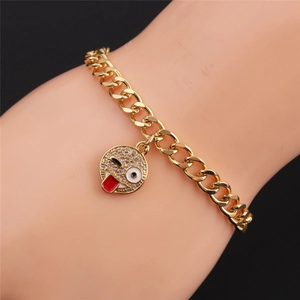 Detail of gold Cuban chain bracelet with a sparkling rhinestone wink emoji charm