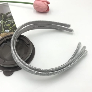 Close-up of three sparkling silver and grey glitter headbands with protective end caps