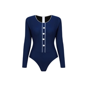 Close-up of navy long-sleeved surf swimsuit featuring white piping and decorative buttons