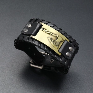 Detail of black leather Viking bracelet with engraved brass axe and Celtic knot patterns