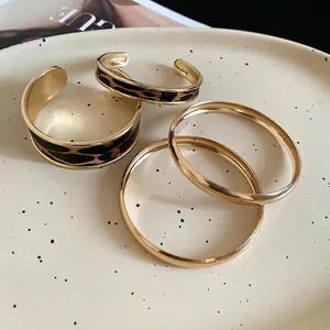 Golden 4-piece bracelet set featuring leopard print patterns and minimalist metal rings