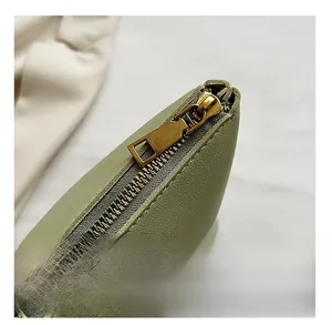 Detail of premium gold metal zipper and smooth texture on light green straw tote bag
