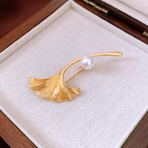 Makroaufnahme einer 18K vergoldeten Ginkgoblatt-Brosche mit Adern und weißer Perle