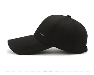 Detail view of the long brim and metal SPORT emblem on a black baseball cap