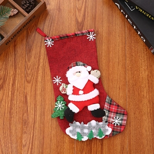 Detail of red linen Christmas stocking with Santa Claus 3D doll and snowflake