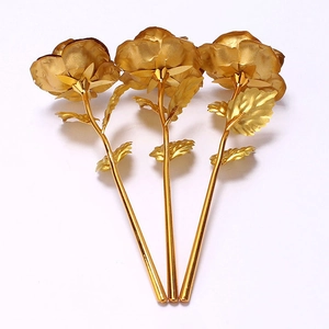 Detailed view of three shimmering gold foil artificial roses with metallic petals and leaves