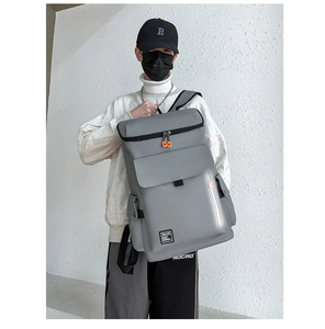 Detail of grey travel backpack with orange zipper pulls and front buckle pocket