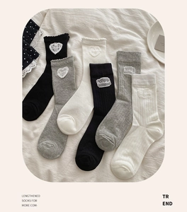 Detailed view of mesh mid-tube socks with heart patches and letter embroidery labels
