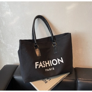 Detail der schwarzen Canvas-Einkaufstasche mit Fashion Paris-Druck und Ledergriffen