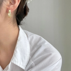 Minimalist 925 sterling silver wavy hoop earrings with golden hammered texture on model