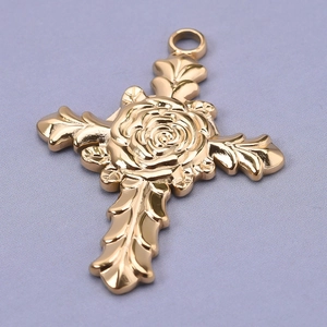 Close-up of 18k gold plated stainless steel rose leaf cross pendant with refined details