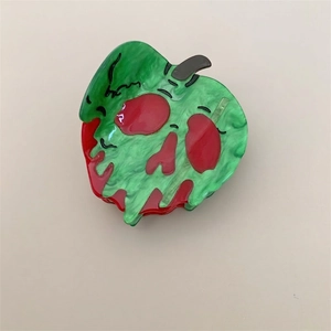 Detailed macro view of acetate hair claw clip in spooky red and green poison apple design