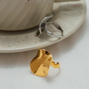Minimalist gold and silver irregular wavy rings with polished finish in a premium scene