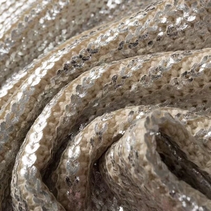 Metallic silver sequin knit fabric detail showing shimmering texture and draped folds