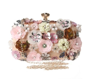 Detailed view of 3D fabric flowers and sequins on an elegant apricot evening clutch bag
