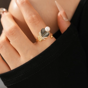 Detail view of leaf ring with gold plating, white pearls, and dark mother of pearl inlay