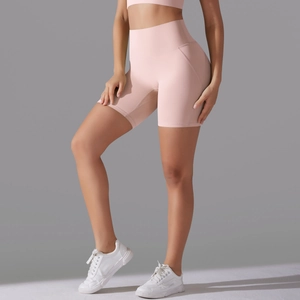 Close-up of light pink high-waisted yoga shorts showing seamless elastic knit fabric
