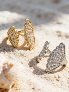 Close-up of gold and silver shell-shaped adjustable rings with shimmering cubic zirconia