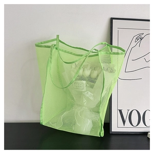 Detalle del bolso tote de malla verde brillante con textura de tela semitransparente