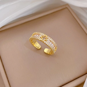 Detaillierte Makroansicht eines vergoldeten verstellbaren Rings mit Sternmuster und Pavé-Diamanten