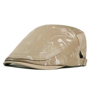 Detail of khaki ivy cap featuring artistic white ink splash print and metal buckle