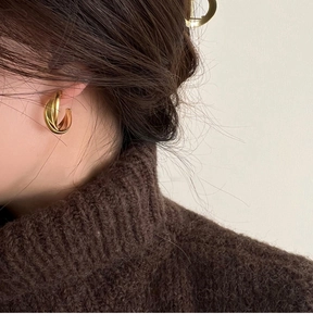 Gros plan d'élégants clips d'oreilles doubles dorés sur un modèle pour un style français