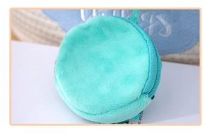 Close-up of mint green round plush coin purse with sparkling sequin trim and zip closure