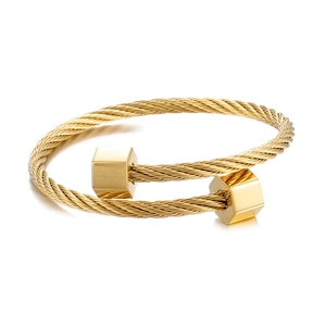 Golden double-layered steel wire rope bracelet with hexagonal geometric ends on white background