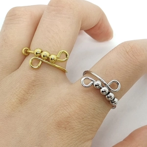 Detail view of gold and silver stainless steel fidget rings with movable beads on finger