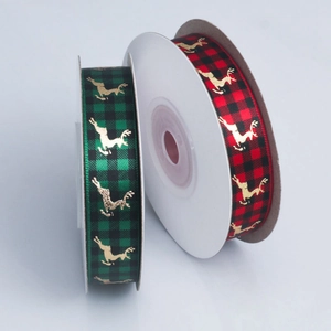 Close-up of red and green plaid Christmas ribbons with gold foil reindeer patterns
