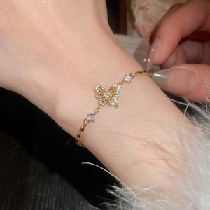 Detail of 18k gold plated butterfly bracelet with sparkling cubic zirconia on model's wrist