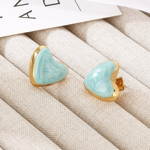 Detailed macro view of mint green enamel heart earrings with polished gold trim