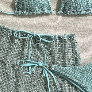 Close-up of mint green crochet beach set showing textured knit and side bow details