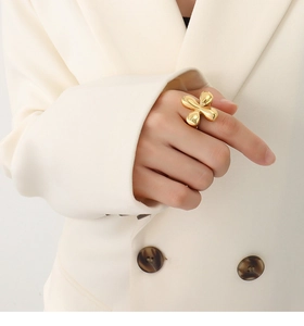 Macro shot of 18k gold plated stainless steel flower ring worn on a finger
