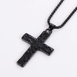 Detailed view of a vintage punk black metal cross pendant with embossed totem patterns