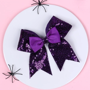 Close-up of purple sequin bow hair clip with ribbons and Halloween spider decor