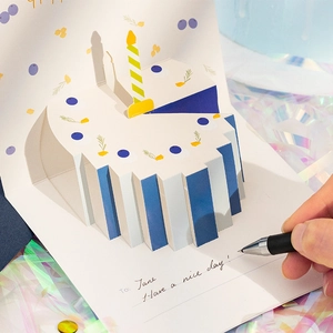 3D pop-up birthday card featuring a blue and white cake with a candle and holographic background