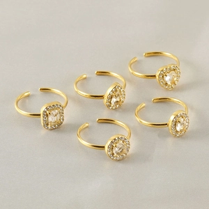 Macro detail of five-piece 18k gold plated adjustable rings with diverse crystal shapes