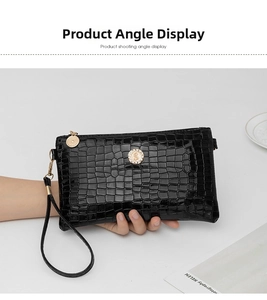 Close-up of black crocodile texture clutch bag with elegant gold S-logo hardware