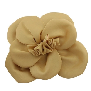 Detailed view of 3D beige fabric camellia flower accessory with layered soft petals
