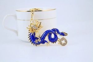 Detail of blue enamel dragon keychain with gold-plated edges and sparkling crystals