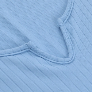 Détail du haut en maille bleu clair à col en V montrant la texture côtelée et la couture