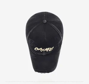 Macro shot of distressed black washed denim baseball cap with torn holes and CAMT embroidery