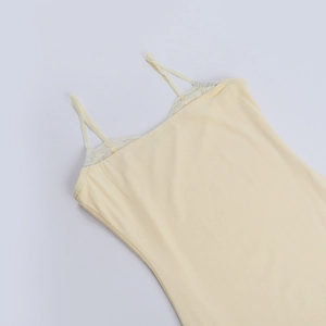Dettaglio del top a canotta giallo pallido con pizzo delicato e tessuto elasticizzato