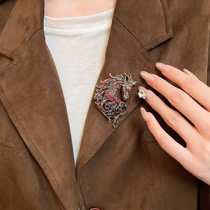 Detailed view of a vintage hollow horse brooch with inlaid diamonds on a model's coat